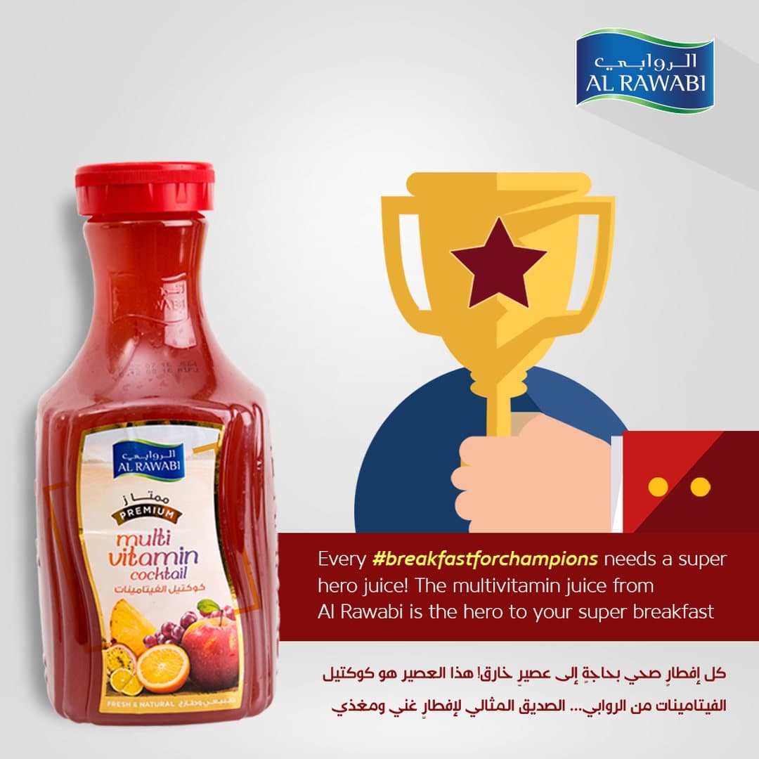 Multivitamin juice bottle beside a gold trophy held by a hand, with a bilingual caption and the hashtag breakfastforchampions